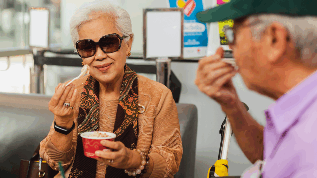 An older couple enjoying ice cream in a cafe