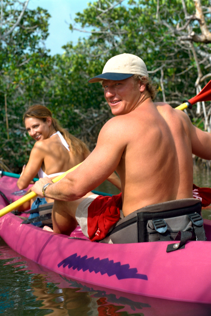 A couple in a kayak, looking back at the viewer